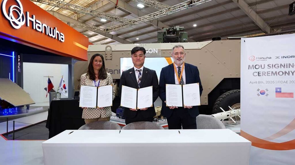 From left, María Dolores Carrillo Aguilera, Head of Ground Systems Business Development at Indra Group; Kim Dong-hyun, Head of the LS Business Division at Hanwha Aerospace; and Domingo Castro Fernández, Head of Indra Group’s Defense Business in South America, pose for a commemorative photo while holding the signed agreement at the MOU signing ceremony during FIDAE 2026, held in Chile on April 8.[Photo: Hanwha]